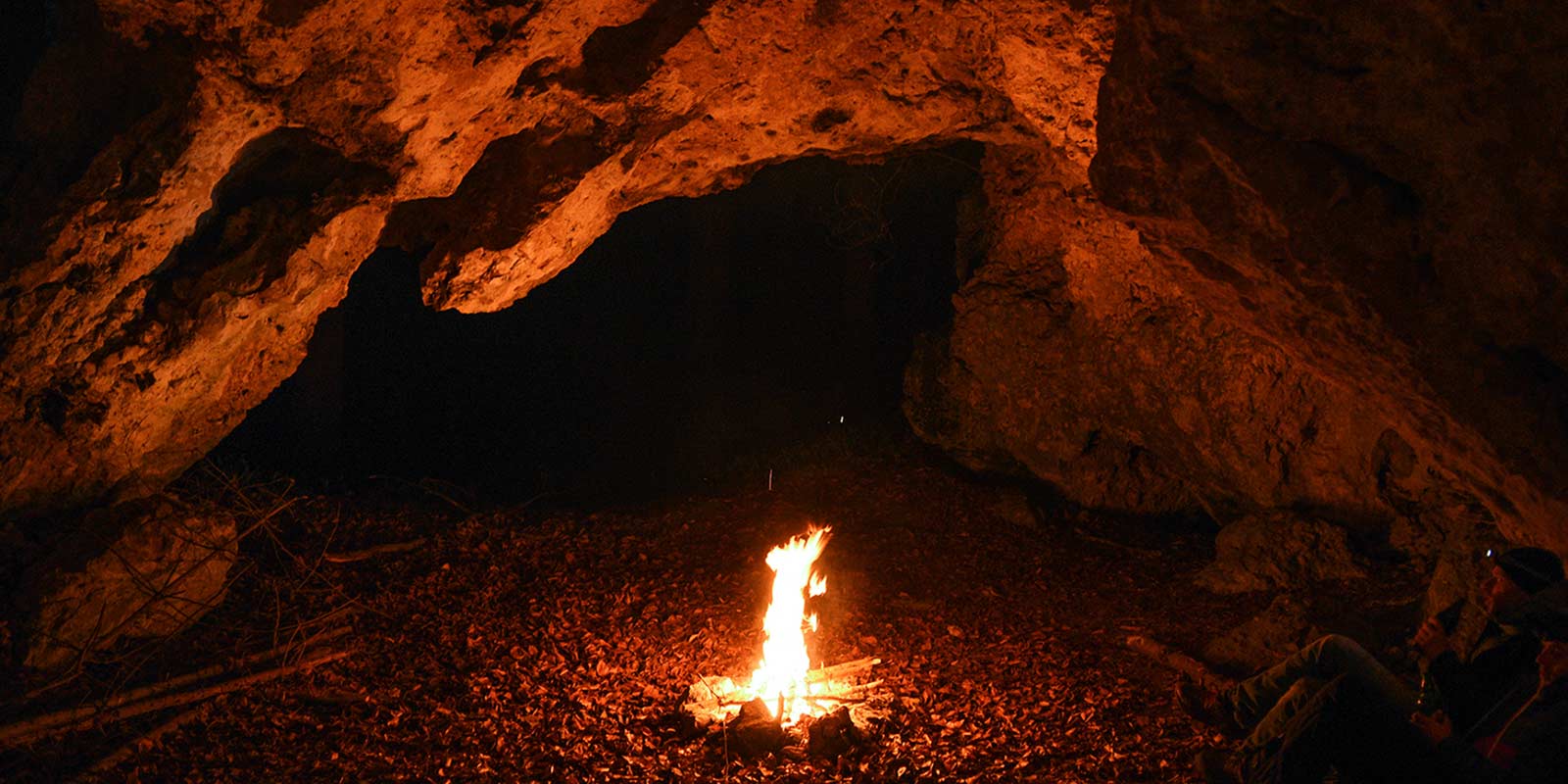 Campfire in a cave representing the earliest gathering place for storytelling, as well as the Holy Spirit.